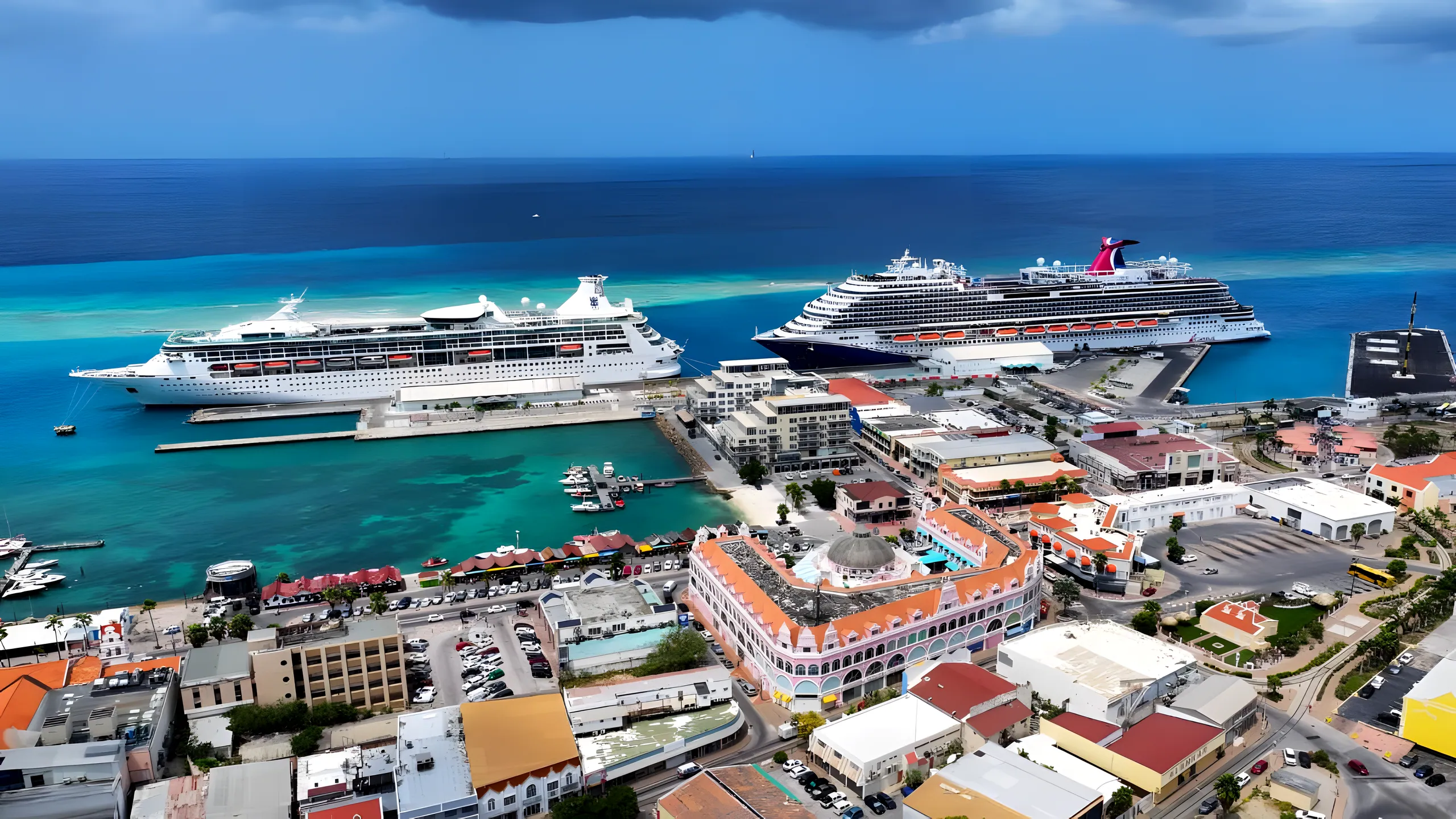 Aerial view of Oranjestad, Aruba — two cruise ships berthed at the terminal, the turquoise marina and the Royal Plaza waterfront